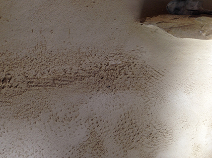 Progettazione e realizzazione di una parete con finitura in terra cruda con intrusioni e pattern superficiali in un’abitazione.