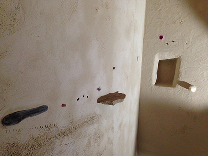 Progettazione e realizzazione di una parete con finitura in terra cruda con intrusioni e pattern superficiali in un’abitazione.