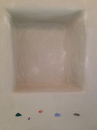 Progettazione e realizzazione di una parete con finitura in terra cruda con intrusioni e pattern superficiali in un’abitazione.