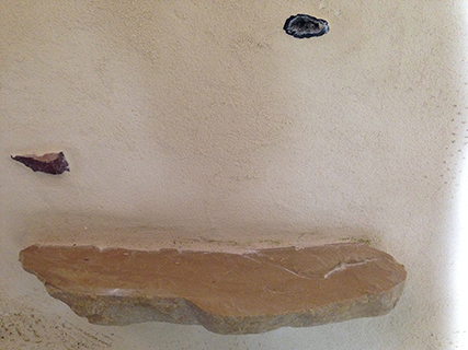 Progettazione e realizzazione di una parete con finitura in terra cruda con intrusioni e pattern superficiali in un’abitazione.