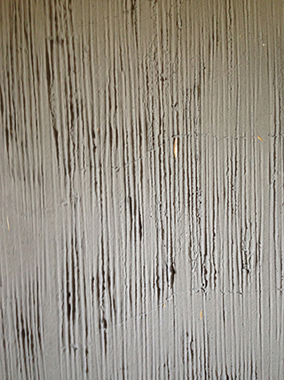 Progettazione e realizzazione di una parete con finitura in terra cruda con intrusioni e pattern superficiali in un’abitazione.