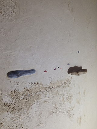 Progettazione e realizzazione di una parete con finitura in terra cruda con intrusioni e pattern superficiali in un’abitazione.