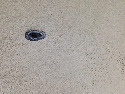Progettazione e realizzazione di una parete con finitura in terra cruda con intrusioni e pattern superficiali in un’abitazione.