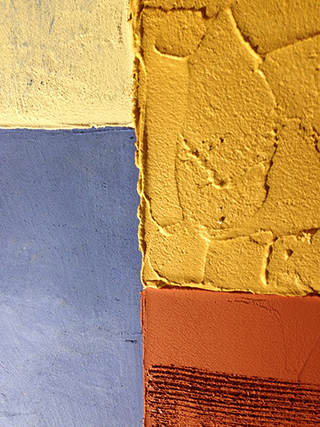 Progettazione e realizzazione di una parete con finitura in terra cruda con intrusioni e pattern superficiali in un’abitazione. Patchwork di Terra