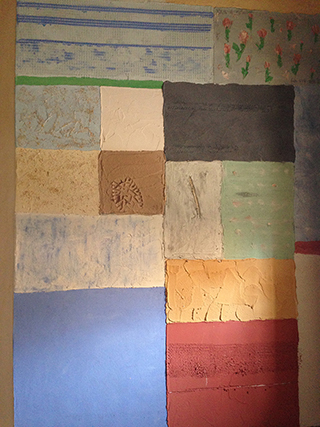 Progettazione e realizzazione di una parete con finitura in terra cruda con intrusioni e pattern superficiali in un’abitazione. Patchwork di Terra