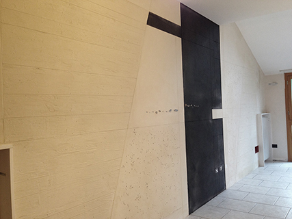 Progettazione e realizzazione controparete isolata acusticamente con finitura in terra cruda con intrusioni e pattern superficiali in un’appartamento mansardato