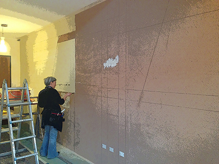 Progettazione e realizzazione controparete isolata acusticamente con finitura in terra cruda con intrusioni e pattern superficiali in un’appartamento mansardato