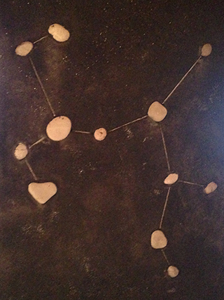 Progettazione e realizzazione di una parete con finitura in terra cruda con intrusioni e pattern superficiali in un’abitazione. Costellazione del Sagittario