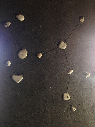 Progettazione e realizzazione di una parete con finitura in terra cruda con intrusioni e pattern superficiali in un’abitazione. Costellazione del Sagittario