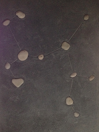 Progettazione e realizzazione di una parete con finitura in terra cruda con intrusioni e pattern superficiali in un’abitazione. Costellazione del Sagittario