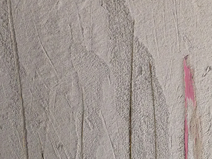 Progettazione e realizzazione di una parete con finitura in terra cruda con intrusioni e pattern superficiali in un’abitazione.
